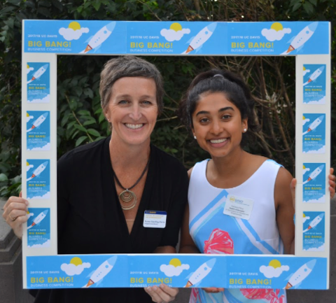 Francesca and a friend hold up a picture frame.