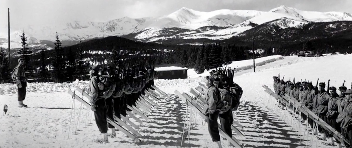 Soldiers stand in rows on snowy mountain.