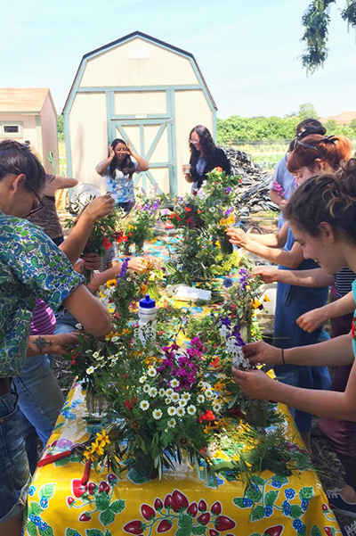 women arranging flowers on a long table