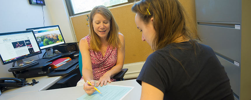 Woman pointing to paper in a session with a female student