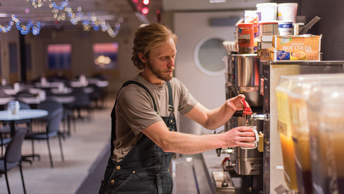 0645 A man gets coffee from a dispenser