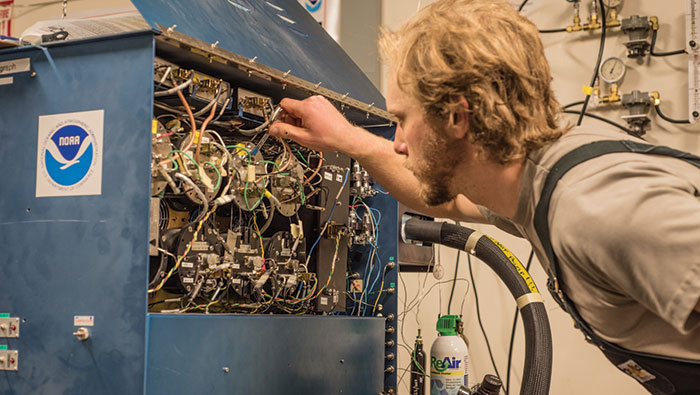 0930 A man adjusts controls on a machine