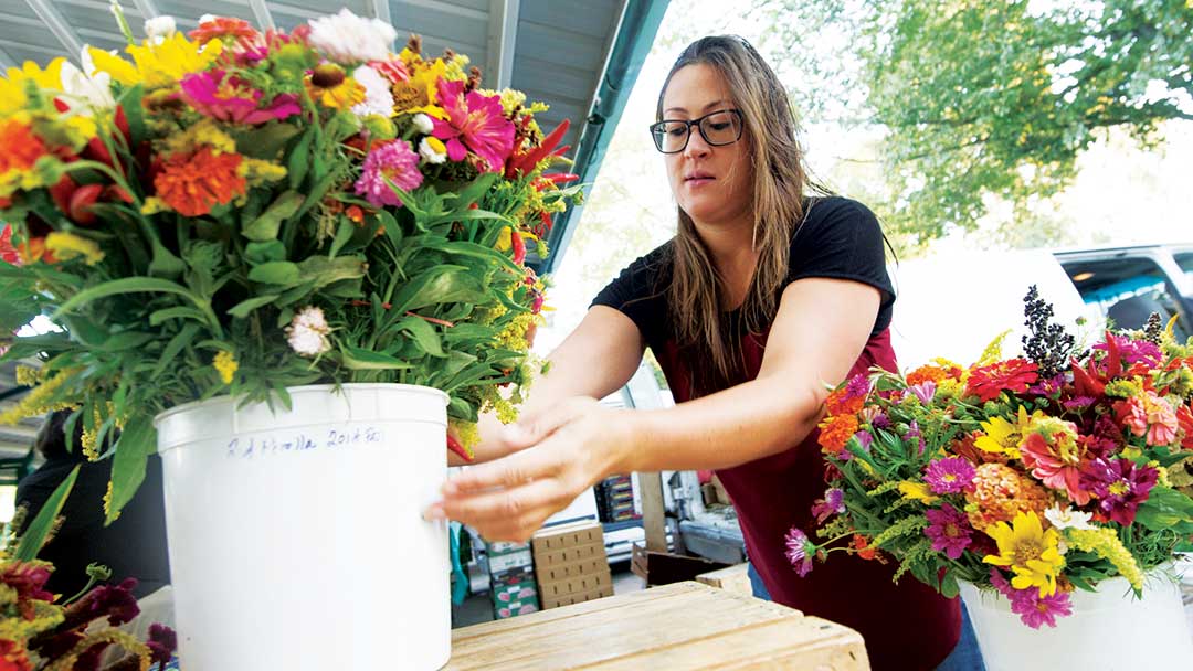 20160917_farmersmarket_001 A woman arranges a bucket of flowers