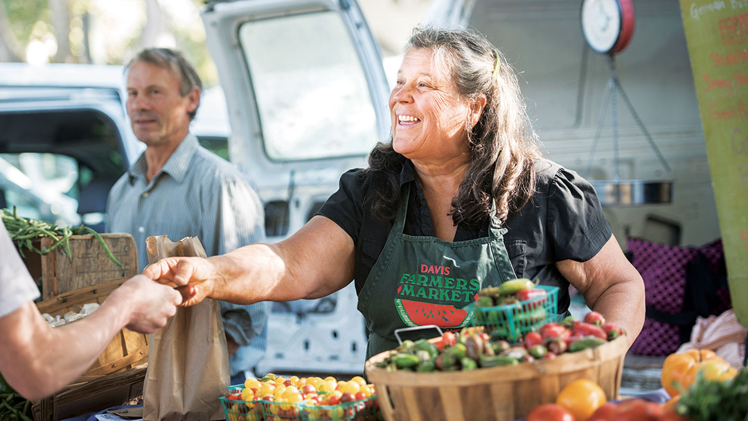 20160917_farmersmarket_010 A woman vendor greets customers at the farmer's market