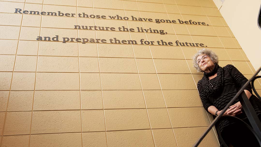 20170110_holocaust_9110 Woman stands in front of sign that reads: Remember those who have gone before...