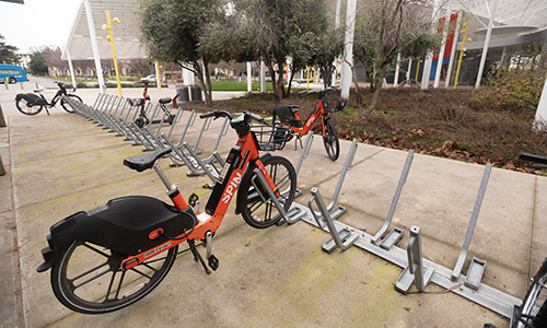 Student-Stories-Spin Electric bikes and scooters parked in racks