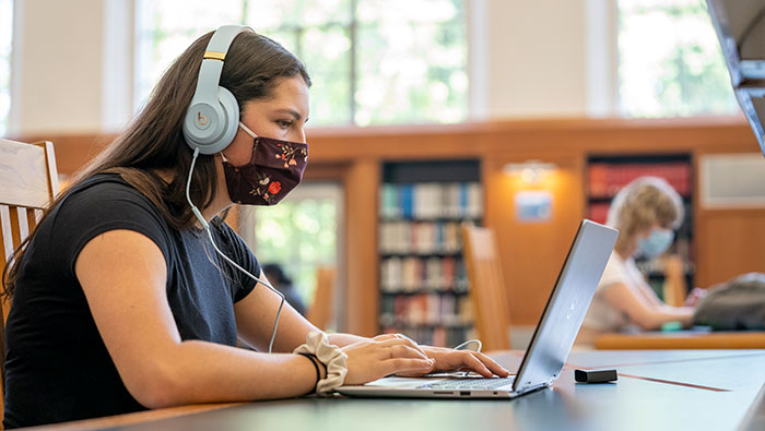 covid-fatigue-web Student studies in library with laptop