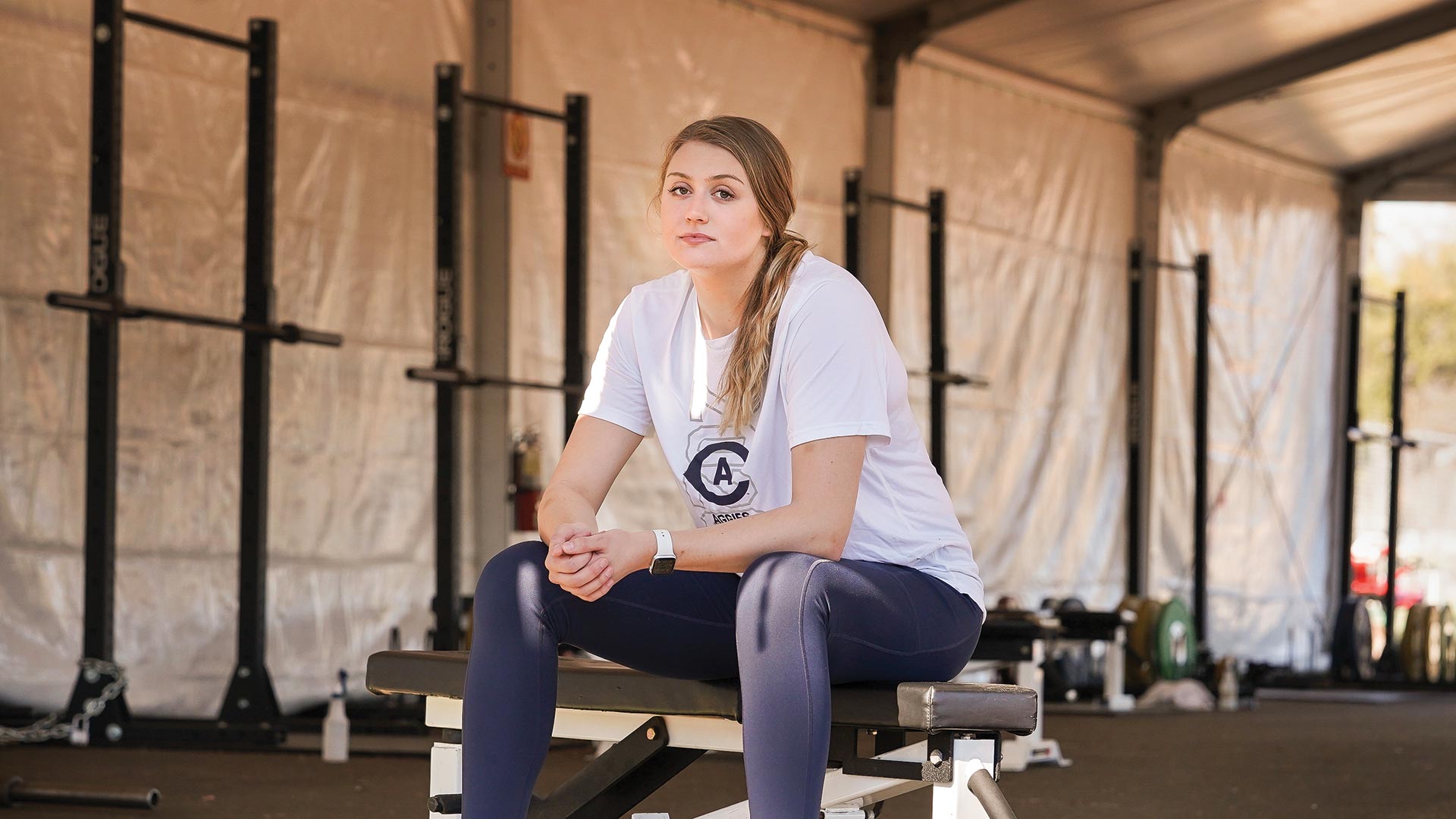 portraits-gibb A student sits on a weight bench in a tent