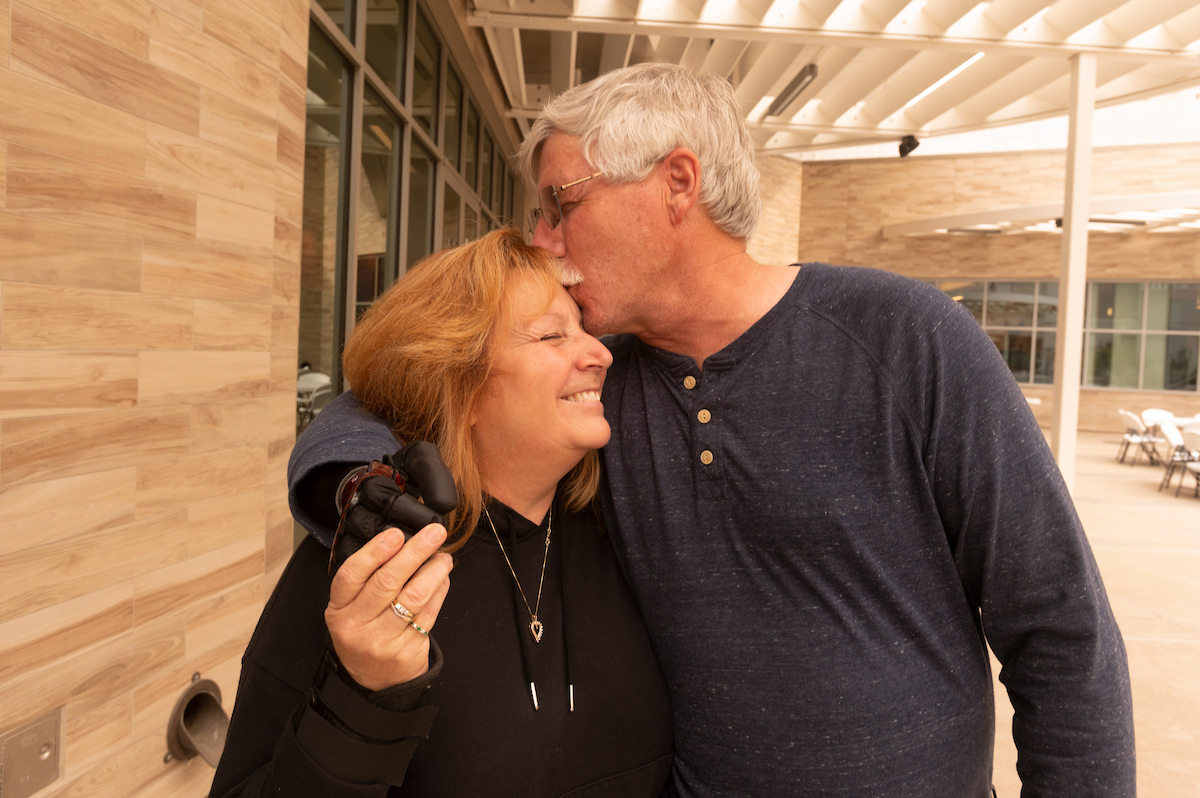 David Brockman gives his wife, Tereasa Brockman, a kiss while at UC Davis after David had a fitting for his prosthetic hand. (Greg Urquiaga/UC Davis)
