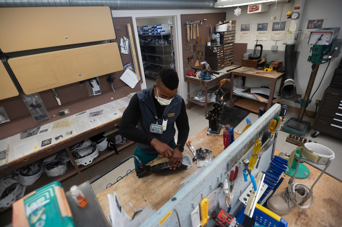 UC Davis Health certified prosthetist orthotist Laduan Smedley works on the fitting for the sleeve of David Brockman's prosthetic hand.