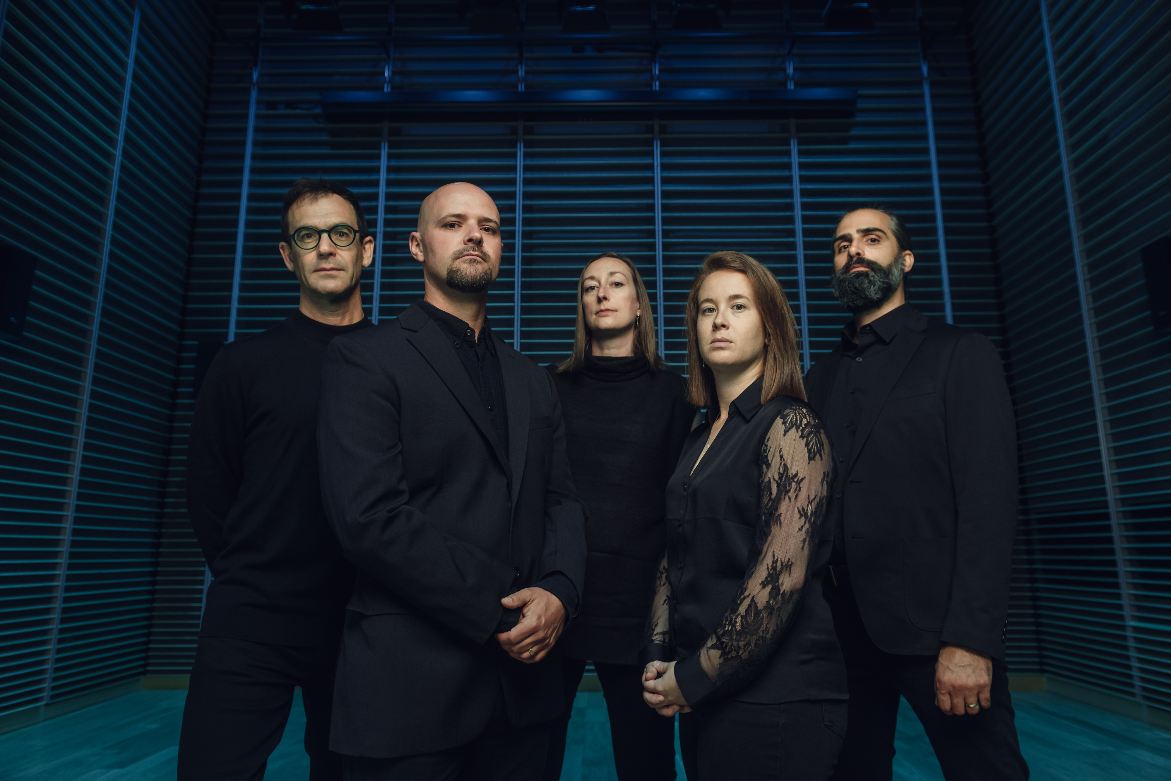 Band of musicians dressed in black on black background