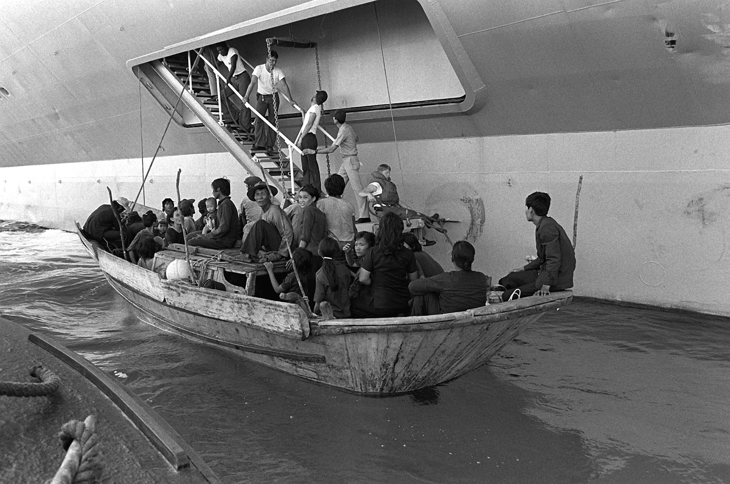Vietnamese refugees in a small boat being loaded onto a U.S. amphibious command ship in 1982.