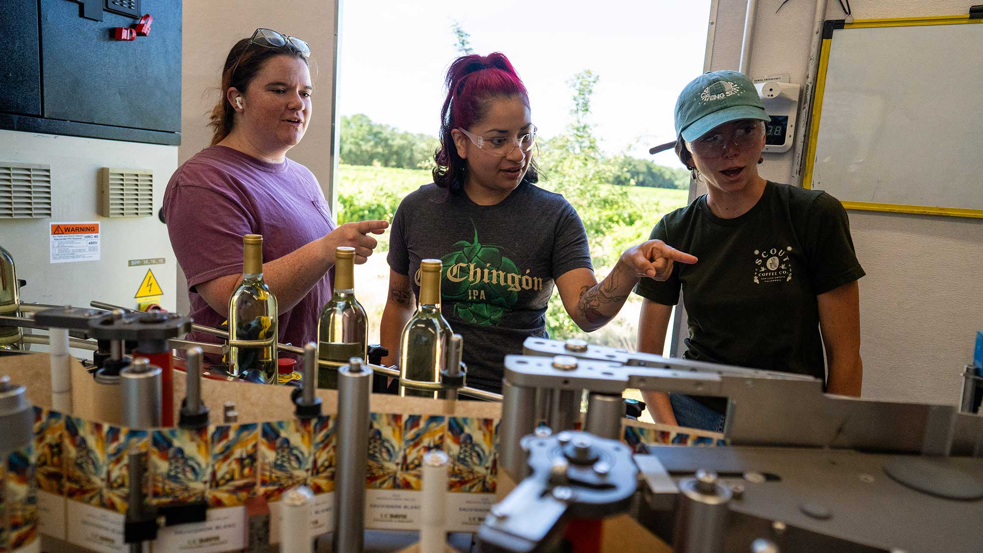 Students in a winemaking class watch as labels are applied