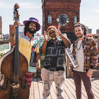 Three men in outdoor setting with musical instruments