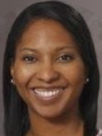 Smiling woman headshot with straight dark hair, pearl stud earrings, gray background