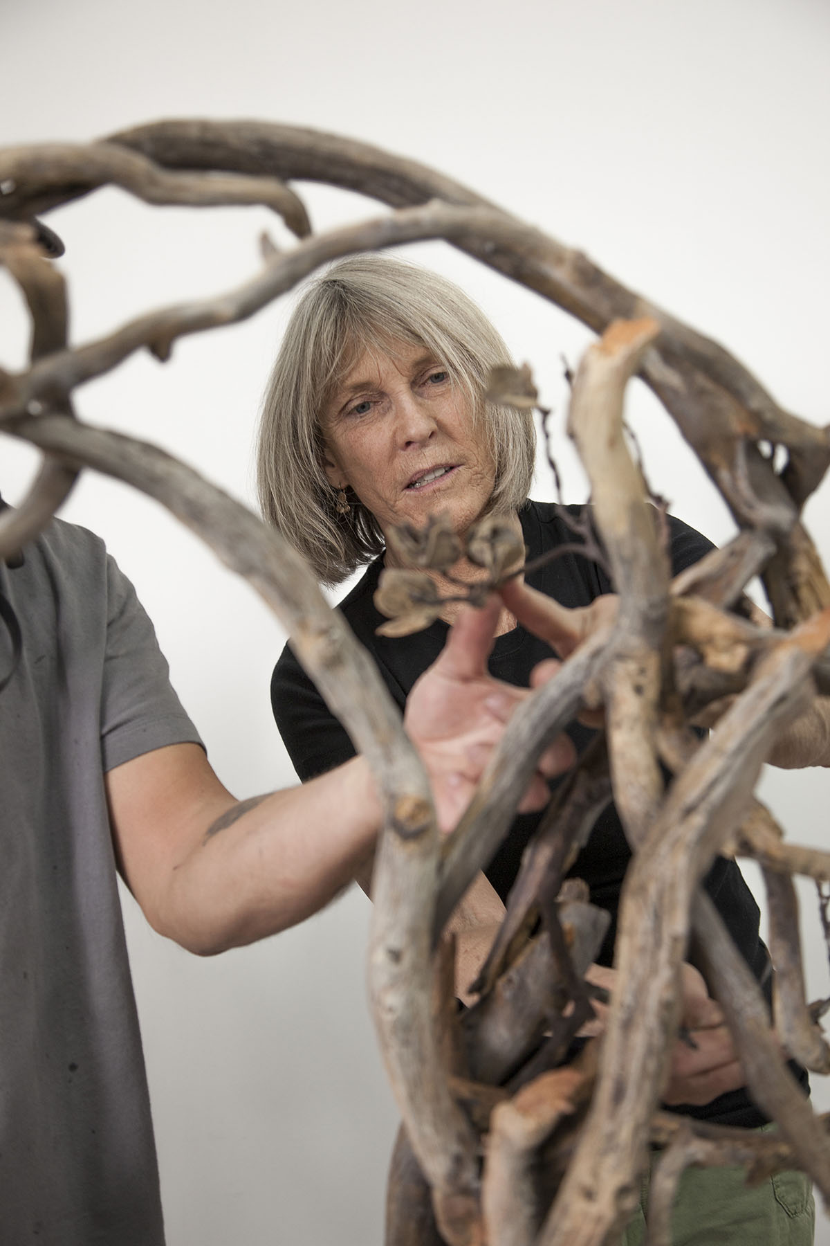 Woman working on sculpture beside another person