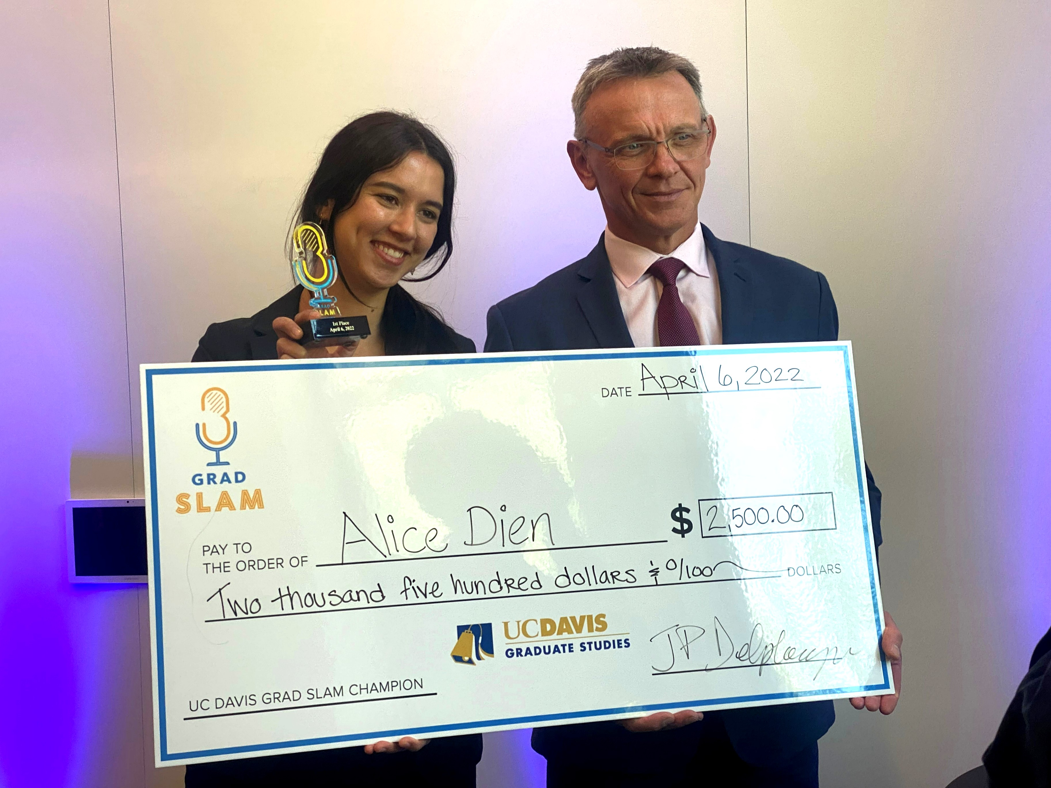 UC Davis Grad Slam 2022 champ Alice Dien holds oversized check with Graduate Studies Dean Jean-Pierre Delplanque