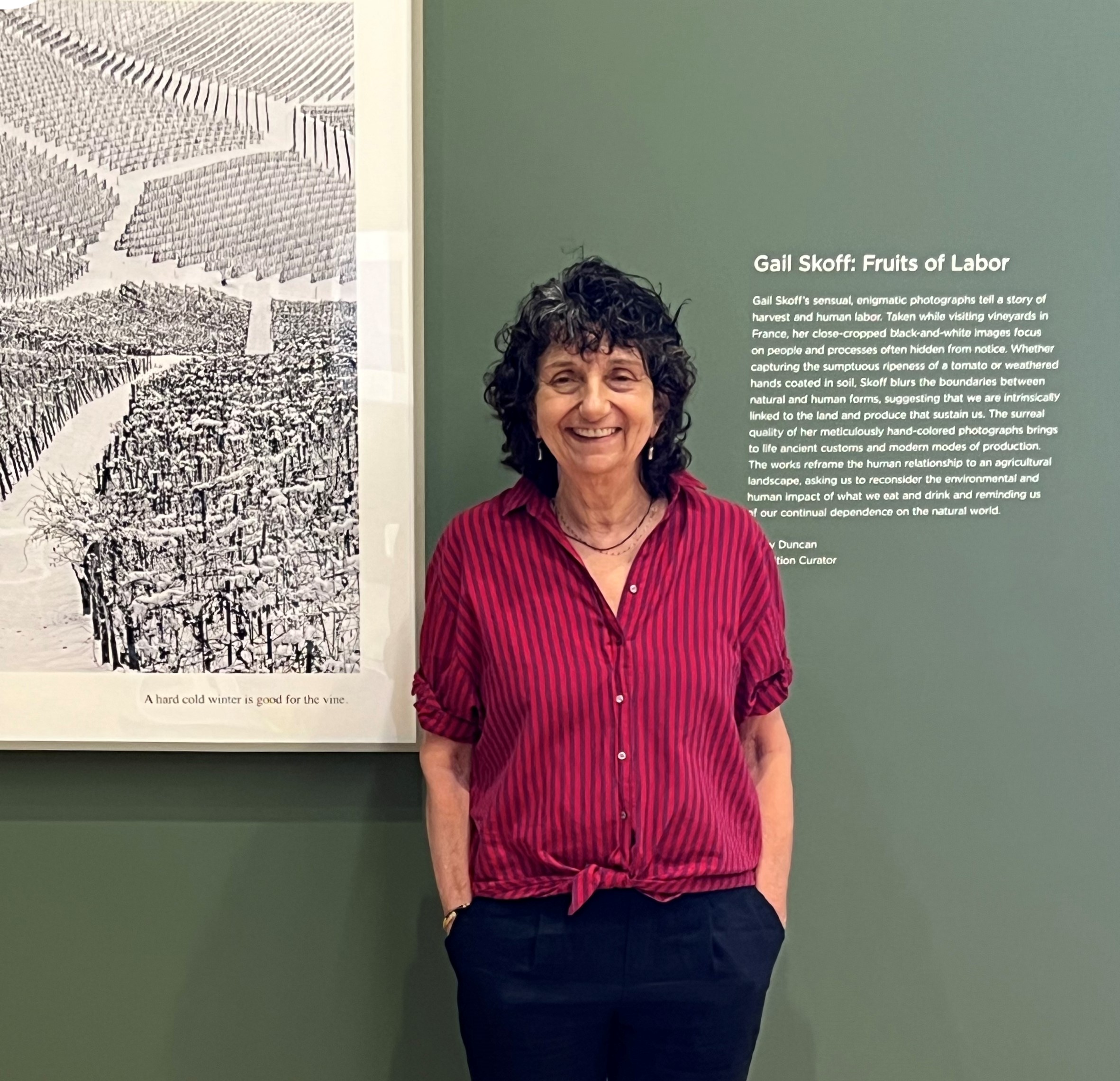 Woman in fed shirt next to artwork at museum