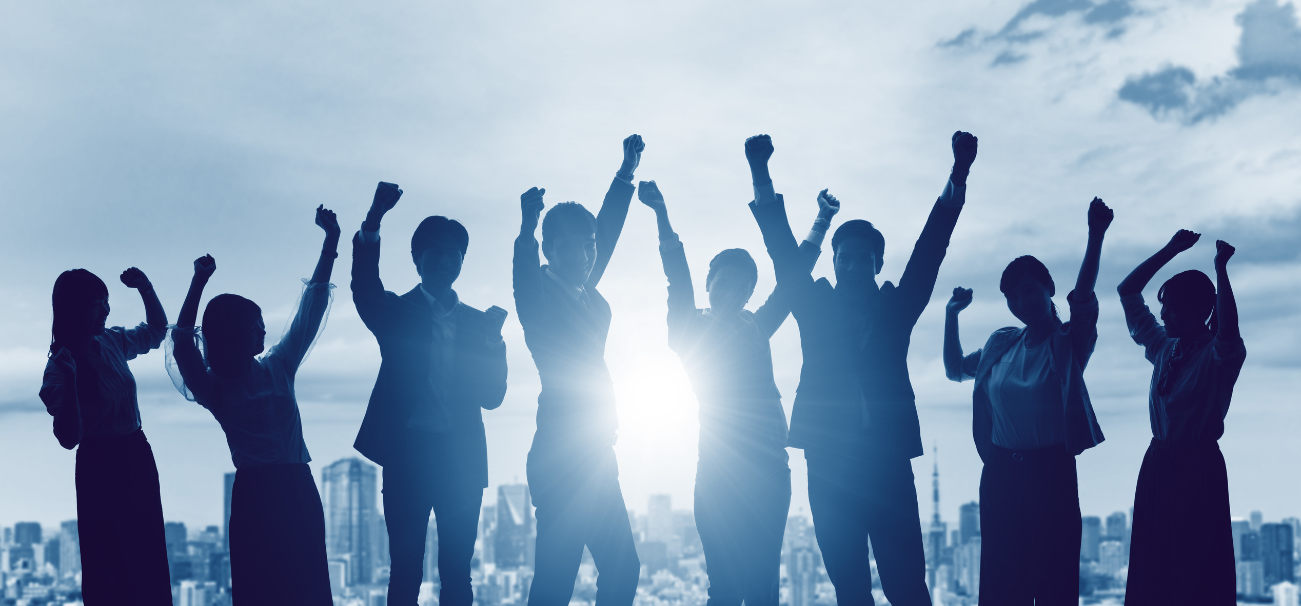 Silhouette of a group of people with arms in the air 