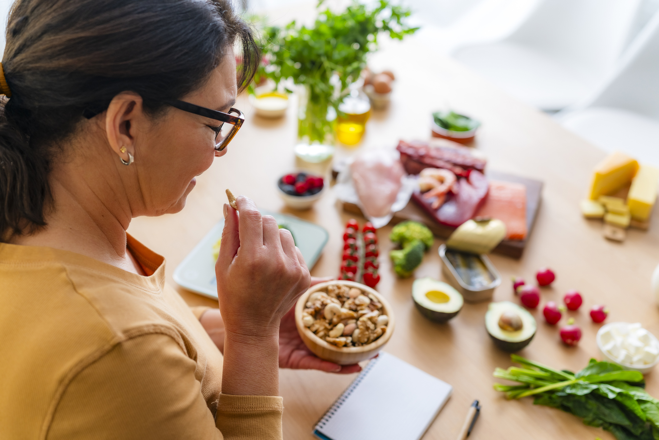 woman eating nuts and other healthy food