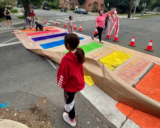 People of many ages chalk out a crosswalk in Davis