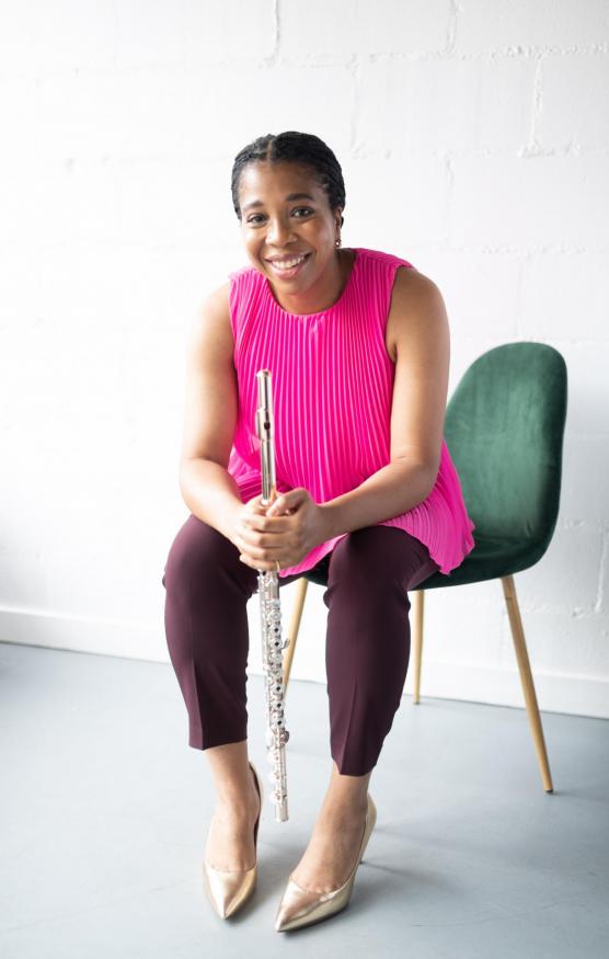 Woman in brightly-colored shirt sits in chair