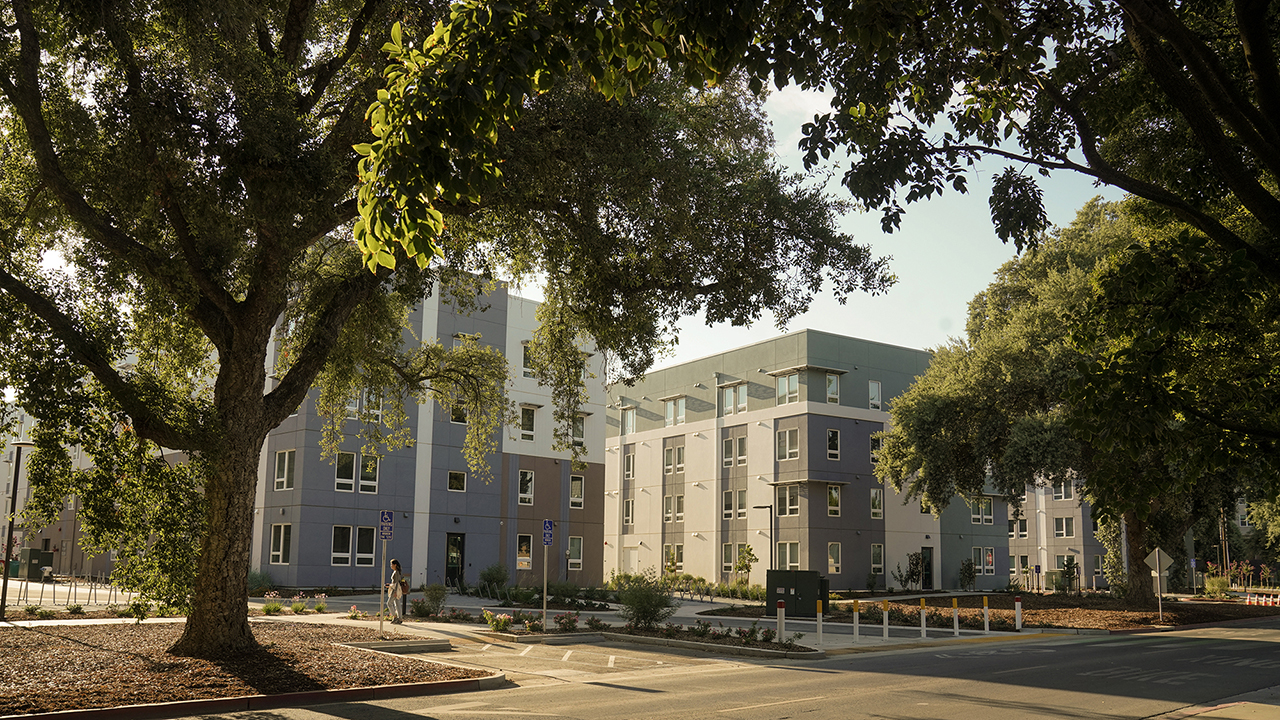 Large trees frame two apartment buildings at Orchard Park