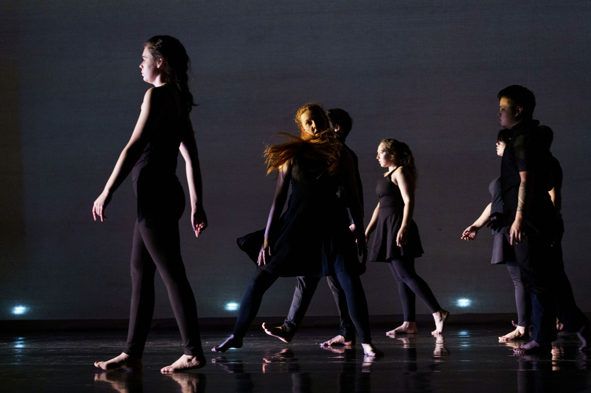 Performers in dark stage dance performance