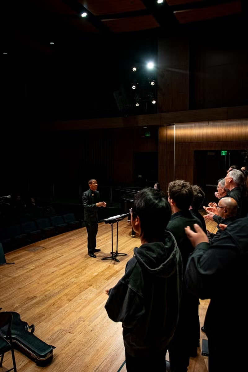 choir rehearses on darkened stage