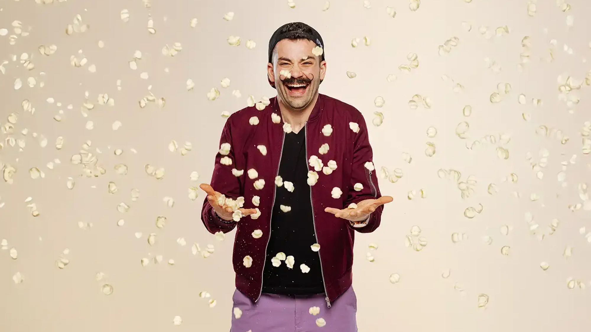 Joe Sasto throws puff chips in the air and laughs