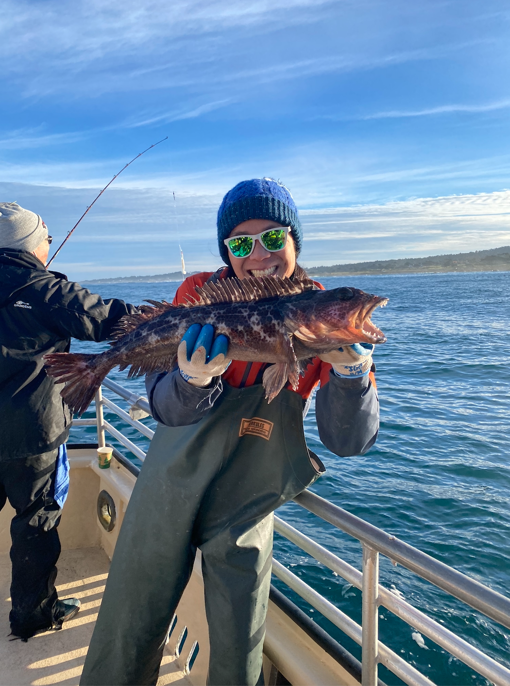 Garfield Kwan holding a fish and smiling 