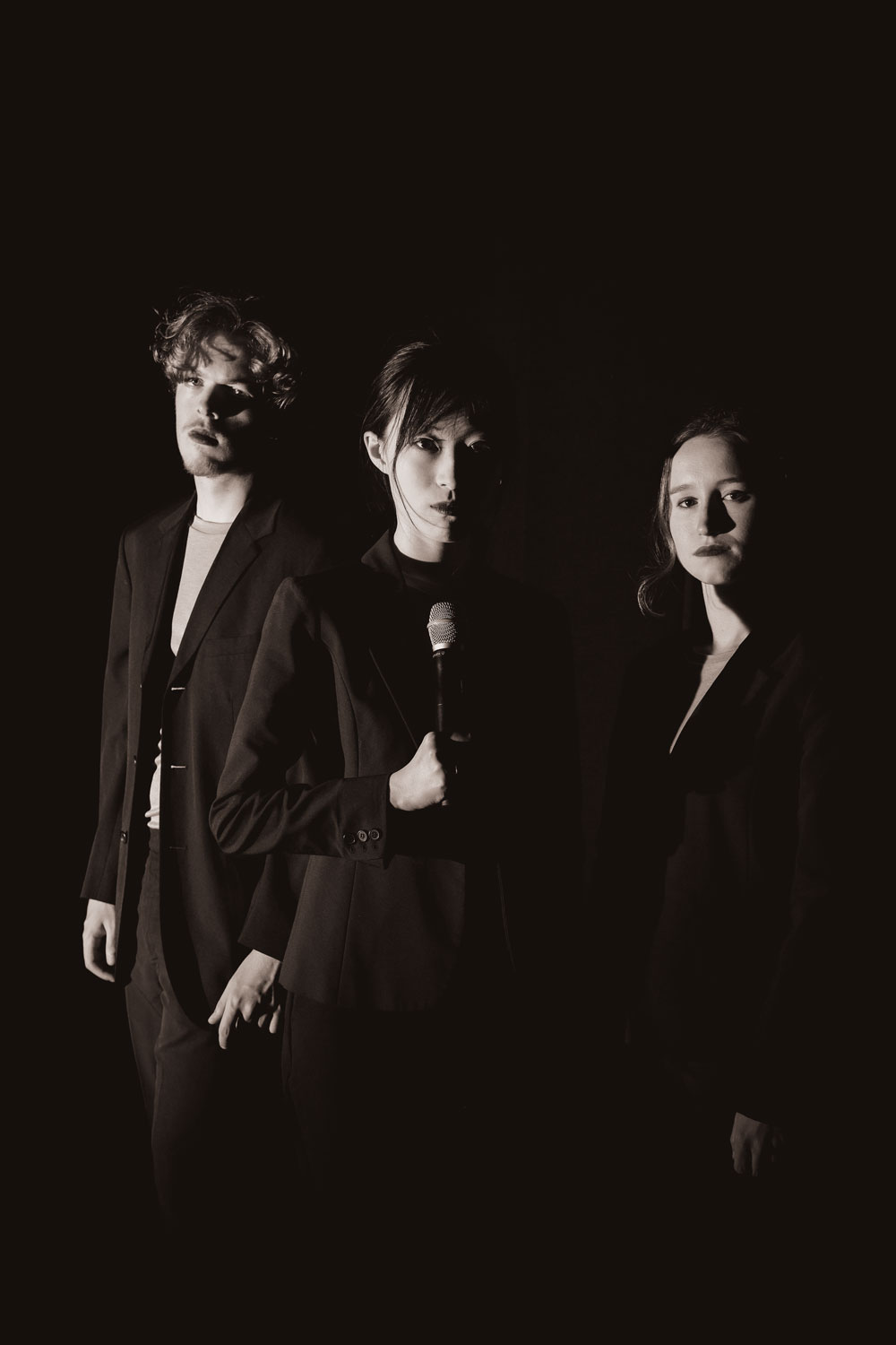 Three actors on stage all dressed in black