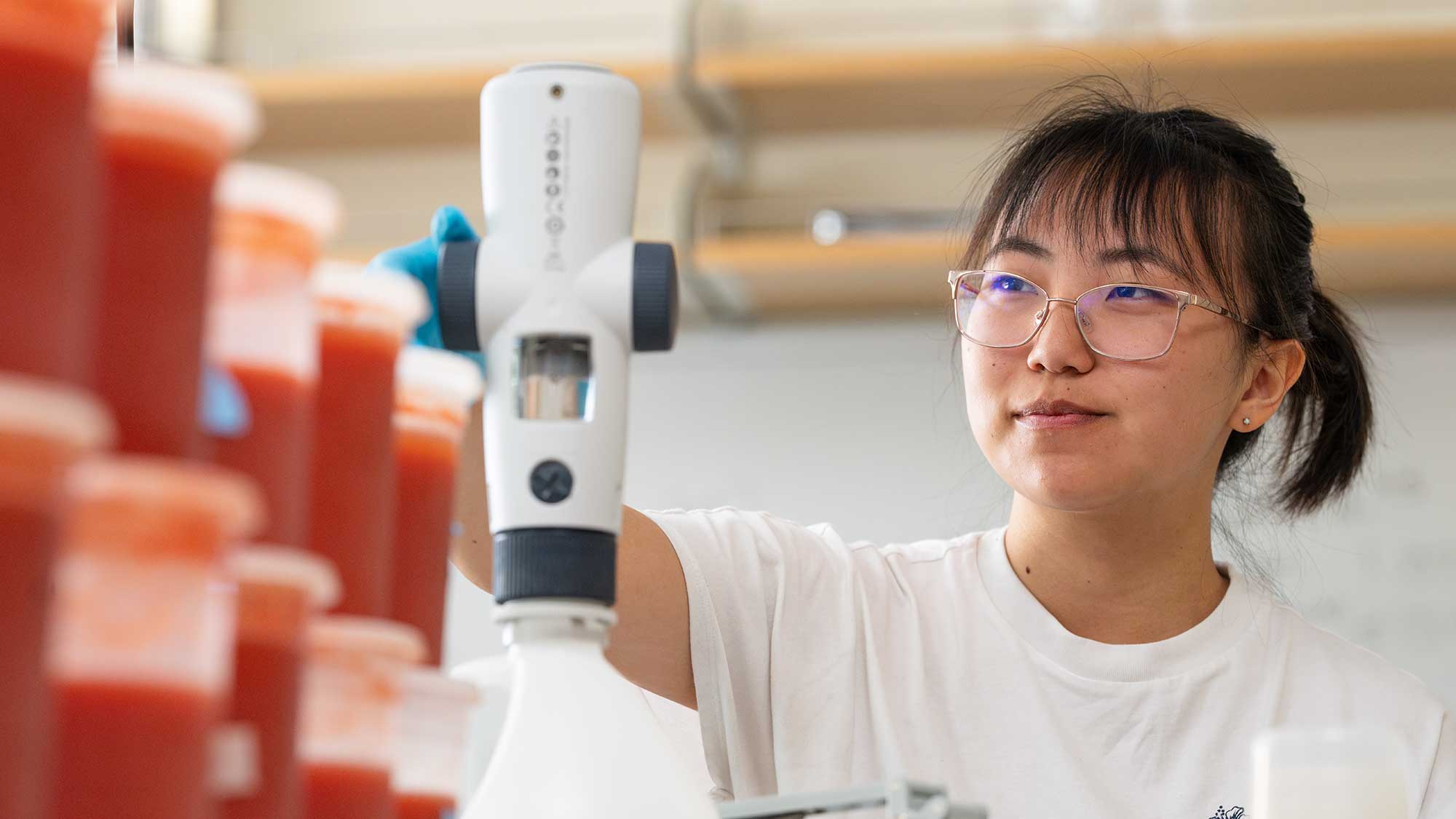 A student analyzing tomato puree as part of a food science and technology class.