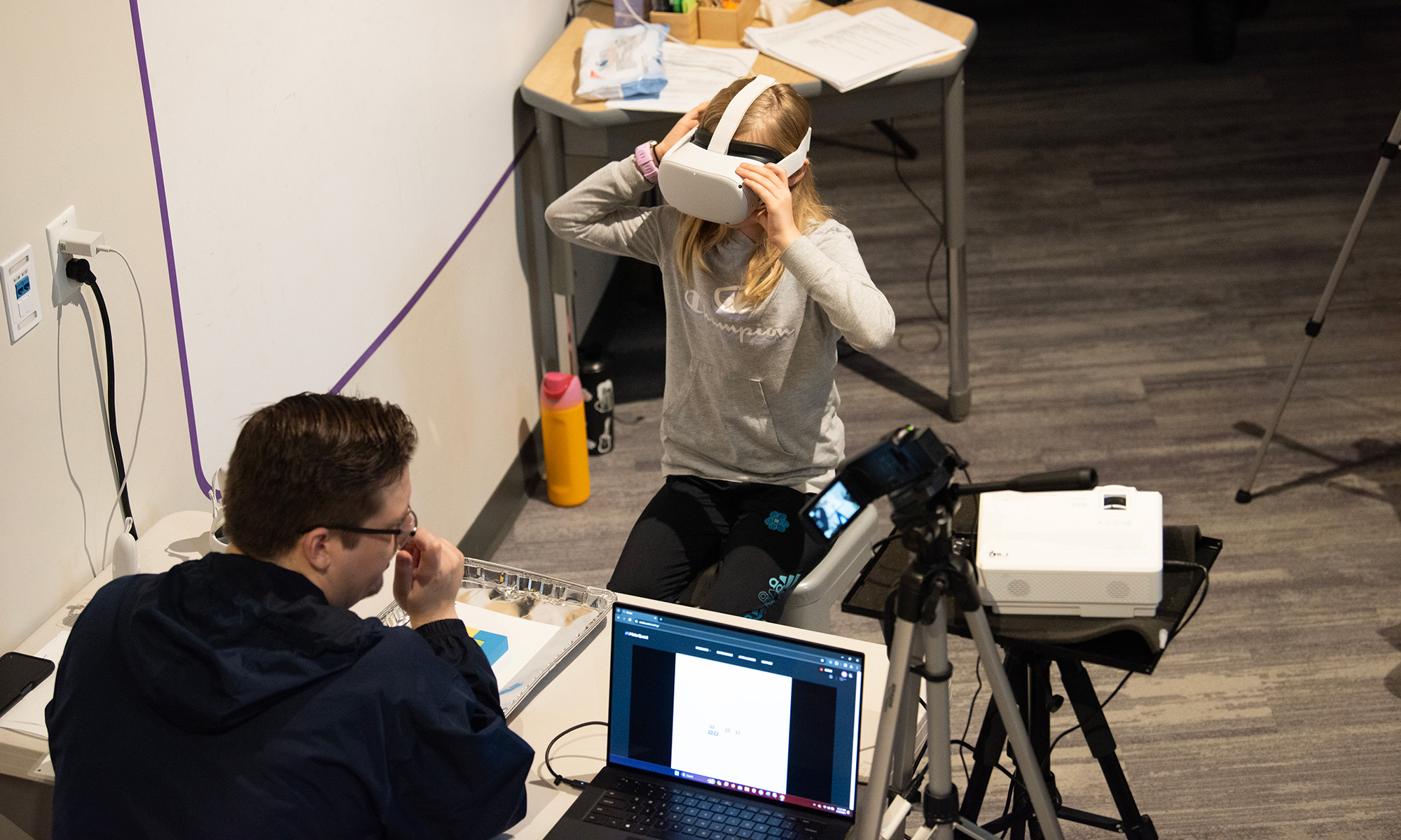 Ph.D. candidate instructs a child on how to use the VR headset.