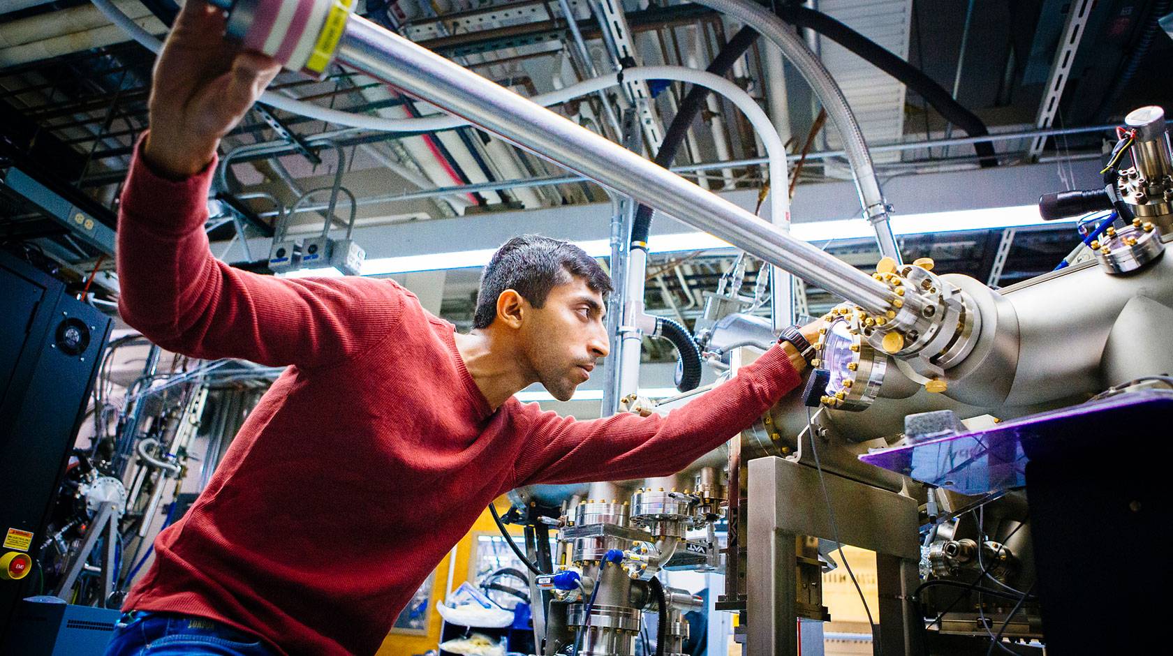 A researcher adjusts some lab machinery