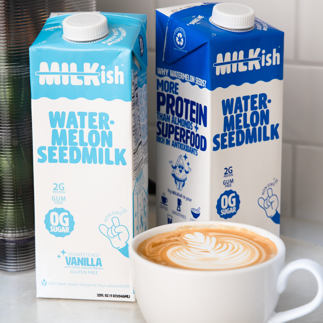 Two Milkish watermelon-seed milk cartons with logo beside a latte with heart latte art