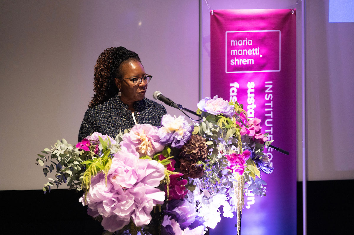 Woman stands at flower-covered lectern