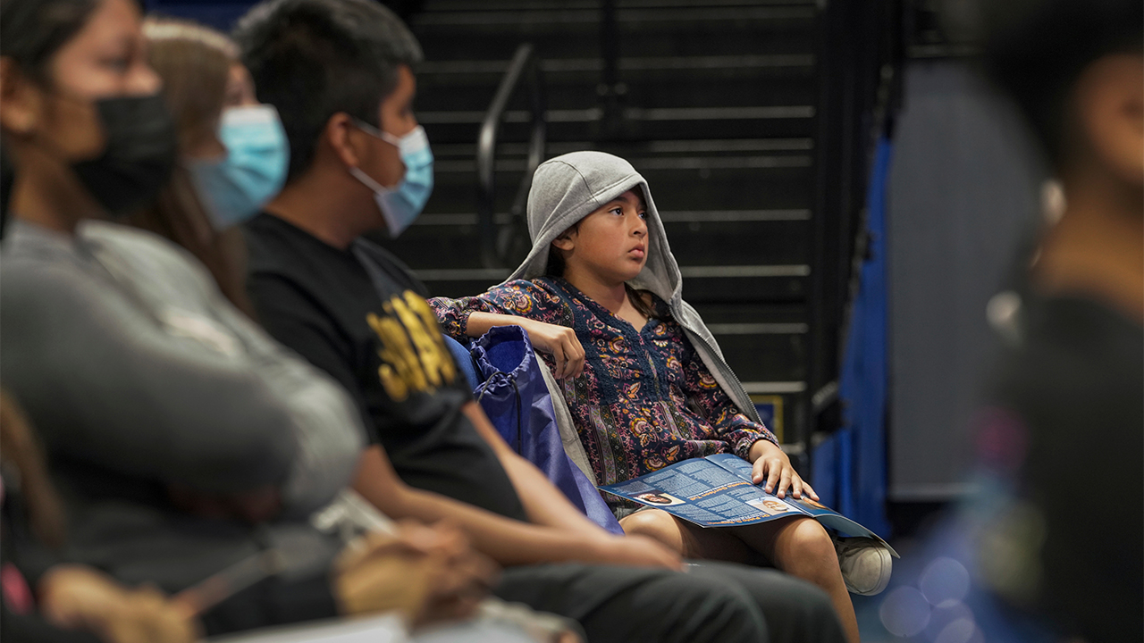 A student seated in the audience listens