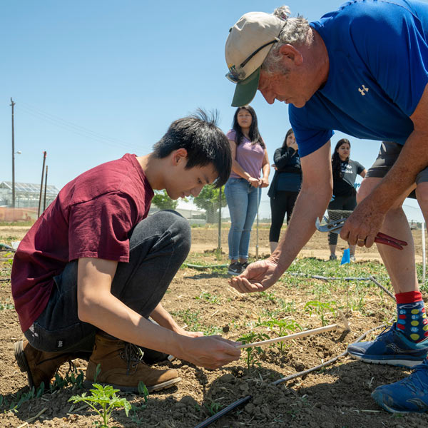 A student and teacher investigate the soil