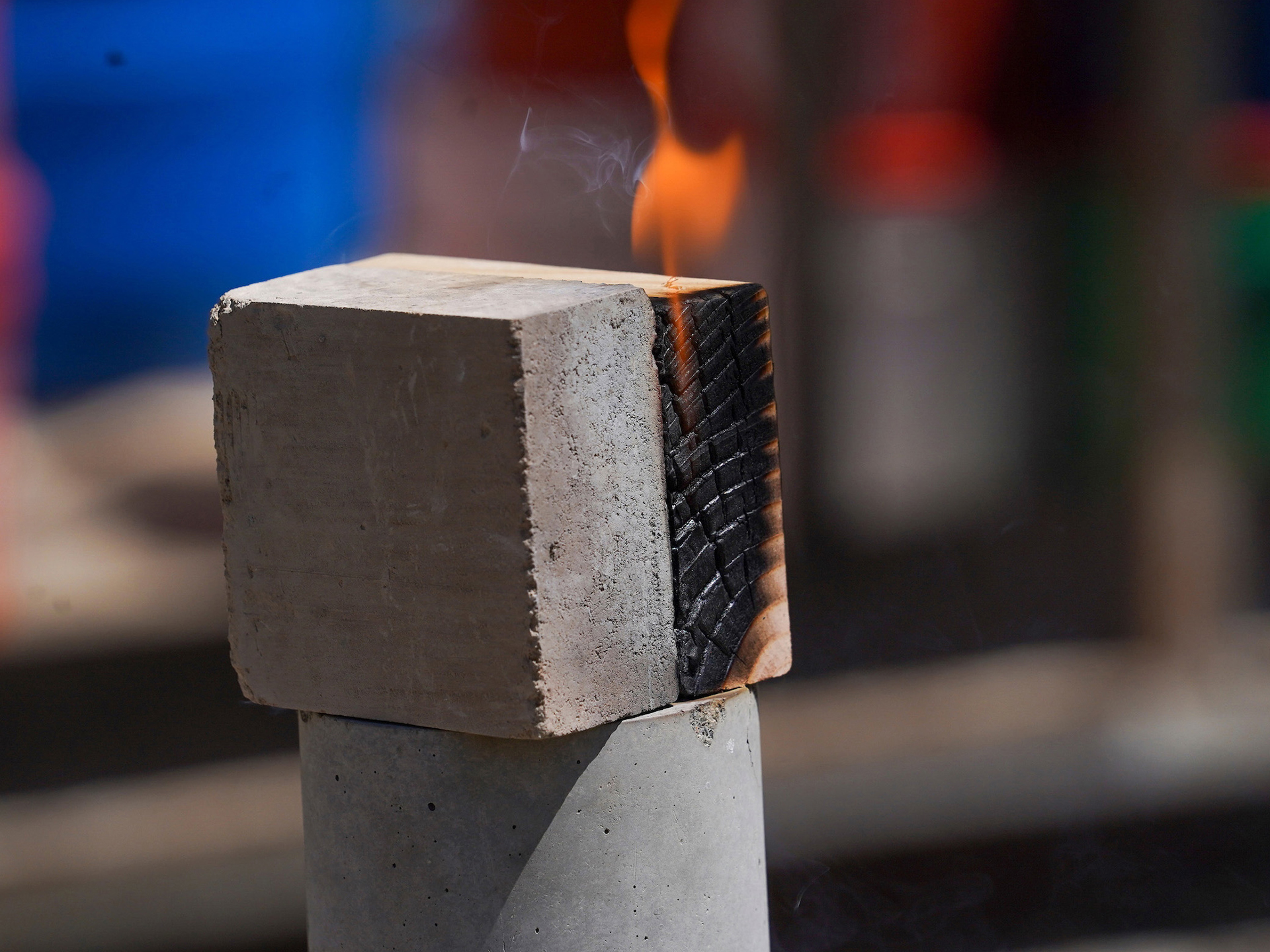 A piece of earth block next to a wooden block. The wood block is scorched and aflame, but the earth block has barely noticeable discoloration.