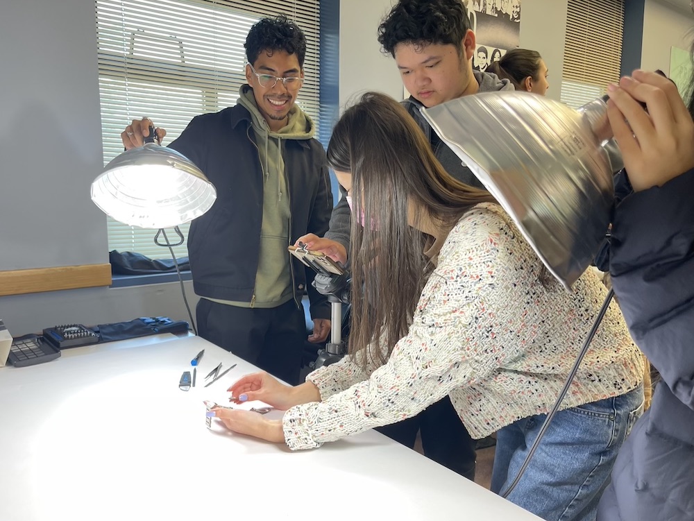 Students gather around lights and technical equipment at UC Davis. 