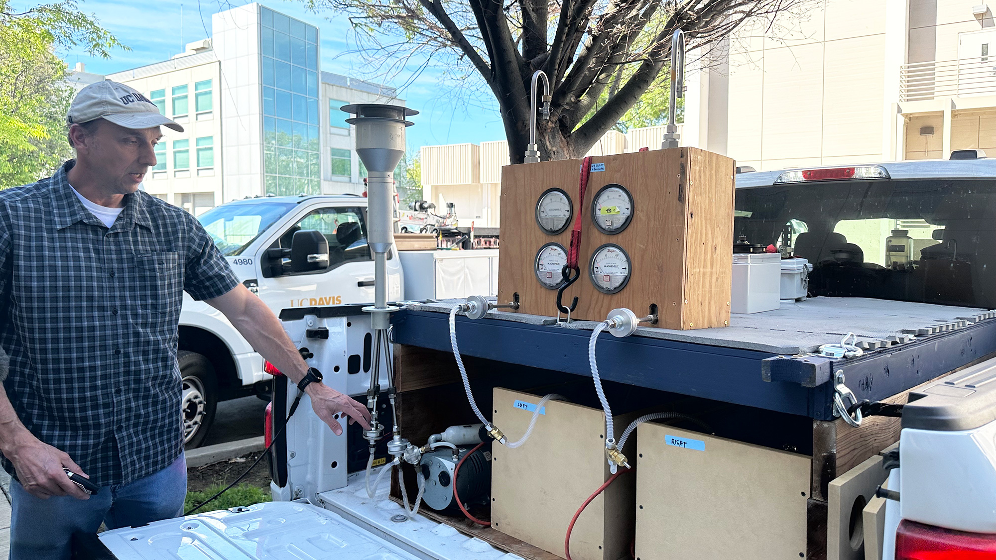 Man shows equipment in the back of a truck bed