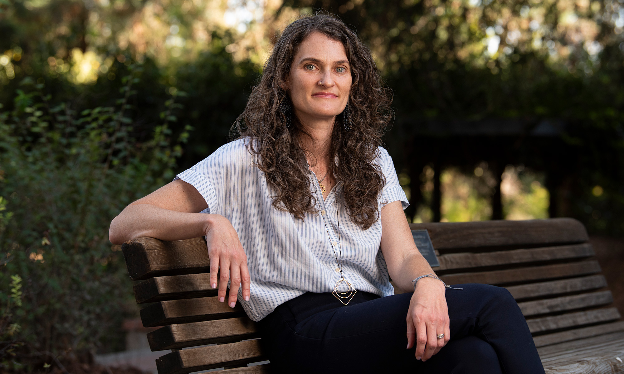 Leah Hibel sits on a park bench on campus