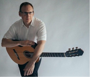 Man in white shirt with guitar