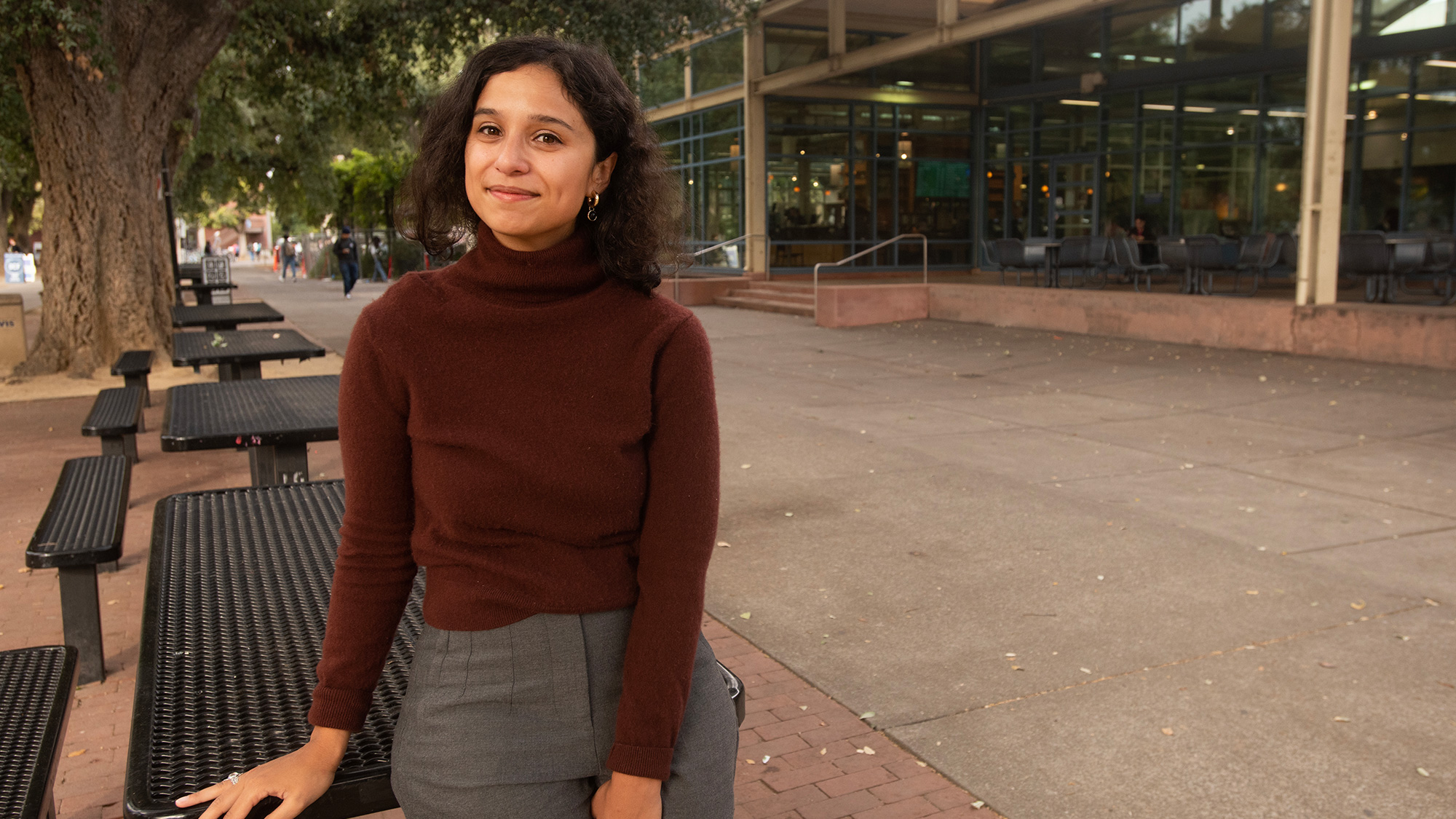 Woman sits at a table near the Memorial Union at UC Davis