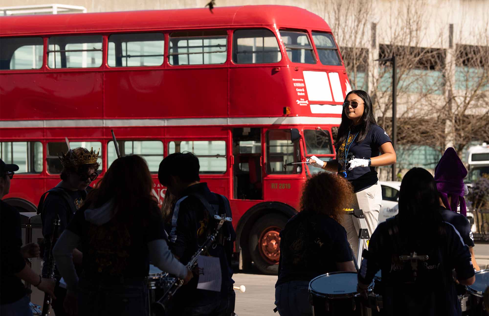 Marching band performs near double-decker Unitrans bus.