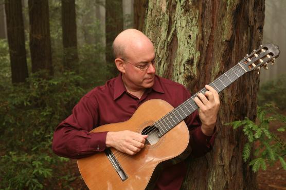 man in red shirt playing guitar