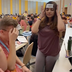 Students hold cards on their heads