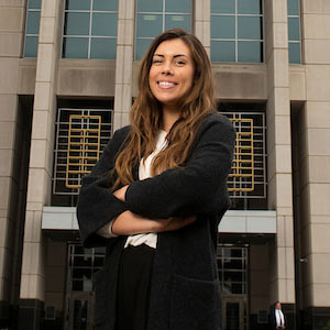 A student stands in front of a city building