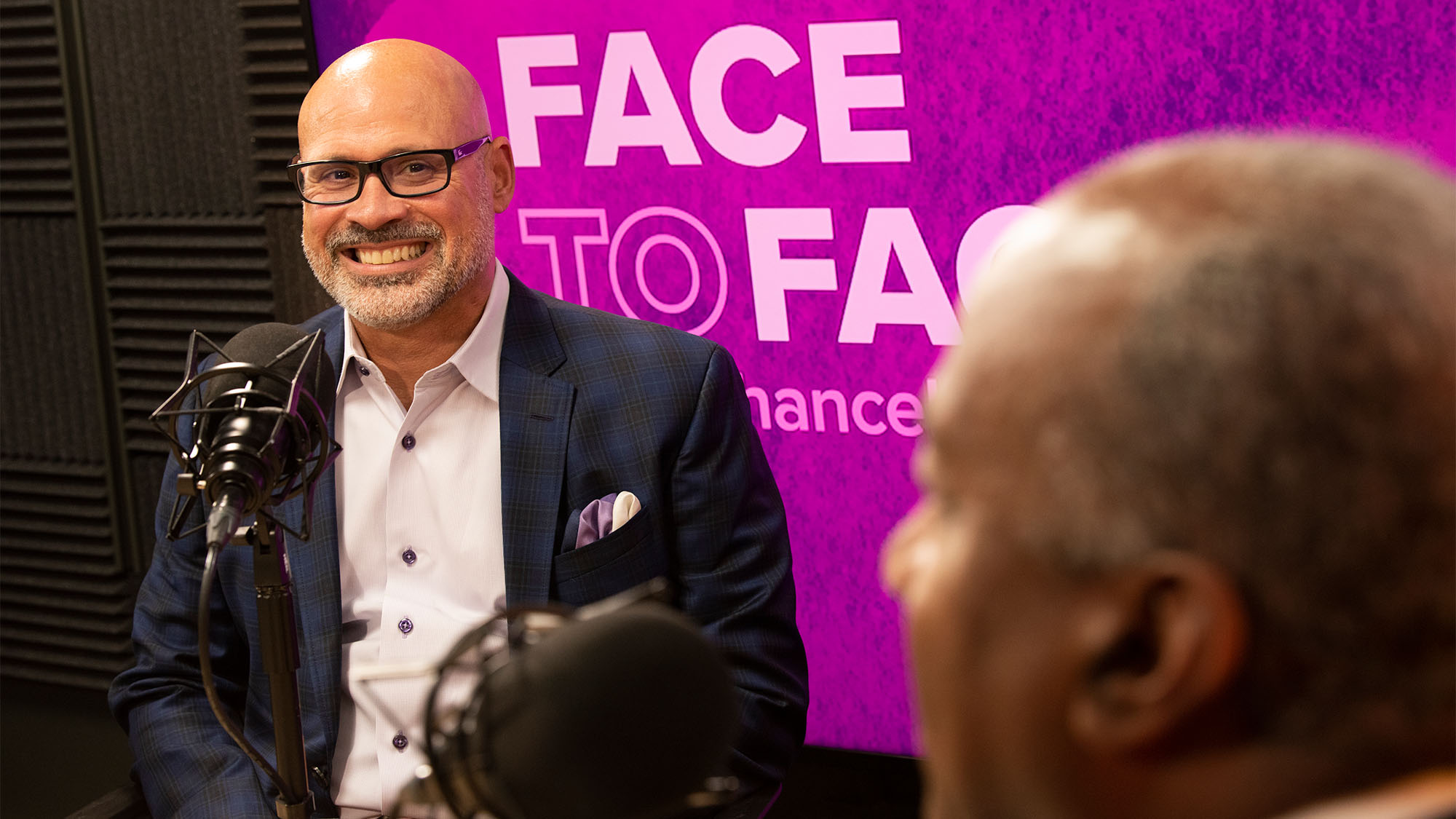 Michael Rios and Chancellor Gary S. May speak in recording studio.